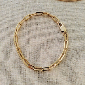 Op de afbeelding: Een gouden kettingarmband met een box chain-ontwerp. De armband is gemaakt van een enkele streng ketting schakels.