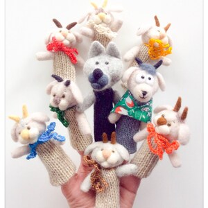 May include: Set of finger puppets featuring a wolf and several goats. The puppets are made of felt and have detailed features. The puppets are wearing colourful scarves and hats.