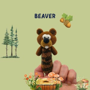 May include: A brown felt beaver finger puppet with a black nose and white teeth. The puppet is held up by a finger. The word "BEAVER" is written in navy blue above the puppet. The background includes illustrations of trees, acorns, and mushrooms.