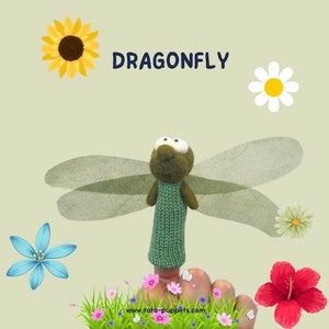 Peut inclure: Marionnette de doigt en feutre verte et marron représentant une libellule avec des ailes vertes. La marionnette est sur un doigt et l'arrière-plan est un motif floral vert et blanc avec le texte "DRAGONFLY" et "www.tata-puppets.com".