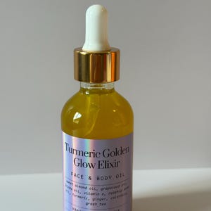 Puede incluir: Botella de vidrio transparente llena de l&iacute;quido amarillo, con un cuentagotas blanco y una tapa dorada. La etiqueta dice "Turmeric Golden Glow Elixir" y enumera los ingredientes. La botella contiene 59 ml.
