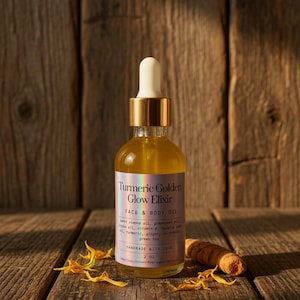 Puede incluir: Una botella de vidrio transparente de aceite facial y corporal Turmeric Golden Glow Elixir con un cuentagotas dorado. La etiqueta enumera ingredientes como aceite de almendras dulces y c&uacute;rcuma. La botella es de 60 ml y est&aacute; sobre madera.