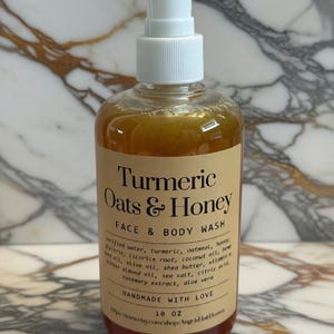 May include: A clear bottle of Turmeric Oats & Honey Face & Body Wash with a white pump dispenser. The label includes the product name, ingredients, and the text "HANDMADE WITH LOVE". The bottle contains approximately 295 ml of product.