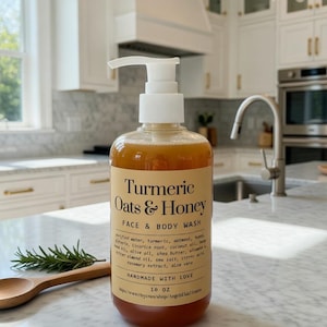 May include: A clear bottle of Turmeric Oats & Honey Face & Body Wash with a white pump dispenser. The label includes the product name and ingredients. The bottle is 295 ml. A wooden spoon and rosemary sprig are next to the bottle.