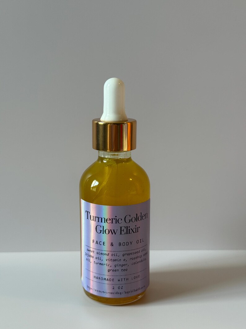 Puede incluir: Una botella de vidrio transparente llena de l&iacute;quido amarillo, con un cuentagotas dorado. La etiqueta dice "Turmeric Golden Glow Elixir FACE & BODY OIL" y enumera los ingredientes. Dice "HANDMADE WITH LOVE" y el volumen es de 60 ml.