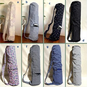 May include: Selection of yoga mat bags in diverse patterns and colours. Designs include floral, polka dots, geometric, and striped fabrics. Each bag has a shoulder strap and a pocket for storage. The bags are designed to carry yoga mats.
