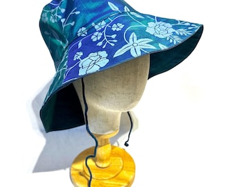 Cappello da sole in pura seta, a tesa larga, pieghevole e con laccetto sottogola.