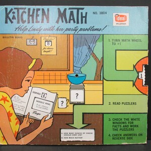 May include: A vintage board game called "Kitchen Math" with a colorful illustration of a girl reading a recipe. The game features a math wheel, puzzlers, and a recipe for a noodle ring. The game is designed to help children learn math skills.
