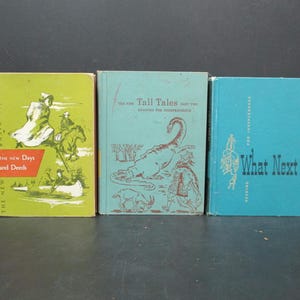 May include: Three vintage children's books with colorful covers. The first book is green and features a woman riding a horse. The second book is blue and features a dinosaur. The third book is blue and features the text "What Next?"