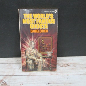 May include: A vintage paperback book titled "The World's Most Famous Ghosts" by Daniel Cohen. The cover features a ghostly image of a man in a suit sitting in a chair with a top hat on a table beside him.