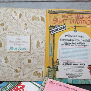 May include: A vintage Little Golden Book titled "Bert's Hall of Great Inventions" featuring Bert and Ernie from Sesame Street. The book cover is yellow with a red sign and a Sesame Street sign. The back cover has a photo of Bert and Ernie.