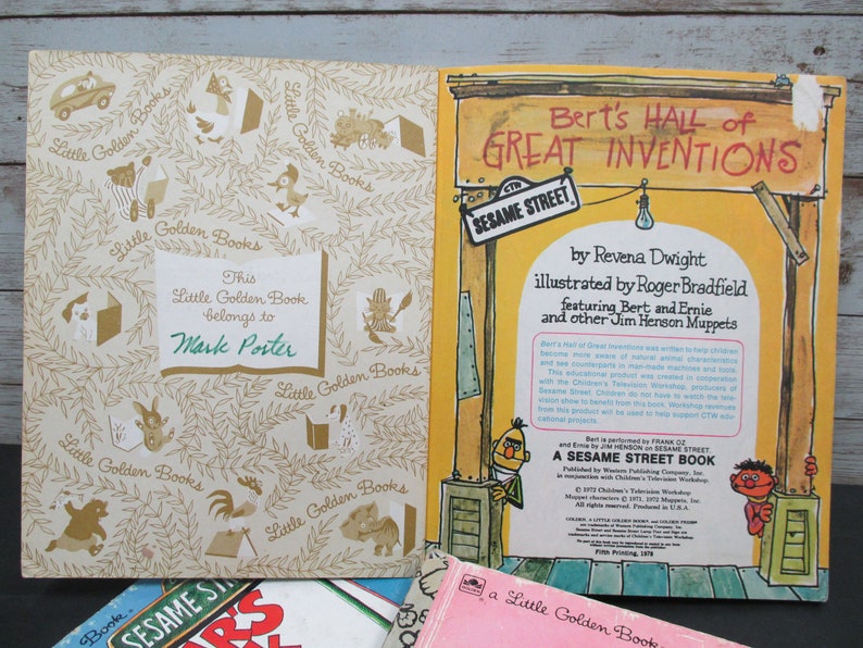 May include: A vintage Little Golden Book titled "Bert's Hall of Great Inventions" featuring Bert and Ernie from Sesame Street. The book cover is yellow with a red sign and a Sesame Street sign. The back cover has a photo of Bert and Ernie.