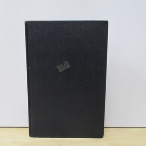 May include: A black hardcover book with a white label on the front cover.