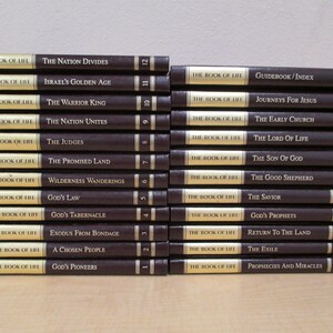 Puede incluir: Una pila de 23 libros marrones con letras doradas. Cada libro tiene el t&iacute;tulo "The Book of Life" y un subt&iacute;tulo diferente. Los subt&iacute;tulos incluyen "The Nation Divides", "Israel's Golden Age", "The Warrior King", "The Nation Unites", "The Judges", "The Promised Land", "Wilderness Wanderings", "God's Law", "God's Tabernacle", "Exodus From Bondage", "A Chosen People", "God's Pioneers", "Guidebook/Index", "Journeys For Jesus", "The Early Church", "The Lord Of Life", "The Son Of God", "The Good Shepherd", "The Saviour", "God's Prophets", "Return To The Land", "The Exile", "Prophecies And Miracles".