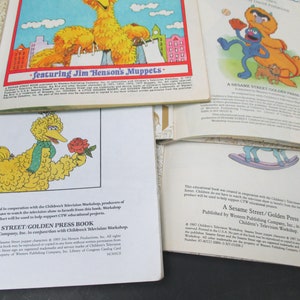 May include: A Sesame Street Golden Press Book featuring Big Bird holding a red rose. The book cover is white with blue text and a yellow background. The book is part of a series of educational books created in cooperation with Children's Television Workshop.