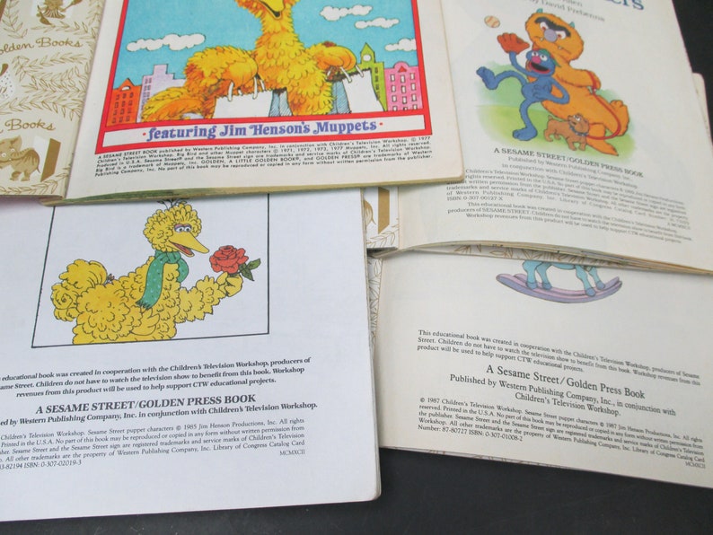 May include: A Sesame Street Golden Press Book featuring Big Bird holding a red rose. The book cover is white with blue text and a yellow background. The book is part of a series of educational books created in cooperation with Children's Television Workshop.