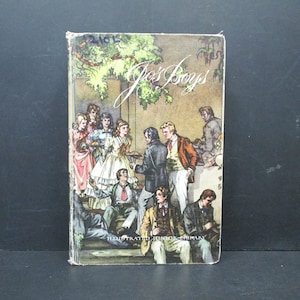 May include: A vintage book cover with the title "Joe's Boys" in cursive script. The cover features an illustration of a group of people, including children, gathered in a garden setting. The book is part of the "Illustrated Junior Library" series.