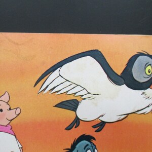 May include: A cartoon illustration of a pink pig wearing a white shirt and a pink scarf, a blue bird with white wings, and a blue and grey bird with a yellow eye. The background is a sunset orange colour.