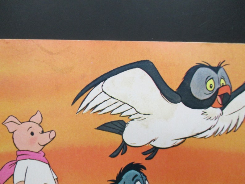 May include: A cartoon illustration of a pink pig wearing a white shirt and a pink scarf, a blue bird with white wings, and a blue and grey bird with a yellow eye. The background is a sunset orange colour.