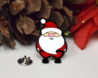 May include: A red and white enamel pin of a smiling Santa Claus with a white beard and black eyes. The pin has a silver backing.