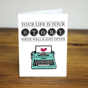 May include: White card with the text "Your life is your story" in black letters with the word "story" in black circles. Below the text is a turquoise typewriter with a pink heart in the paper. The text "Write well & edit often" is below the typewriter.