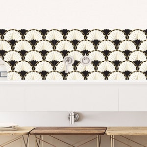 Op de afbeelding: Zwarte en gouden geometrische betegelde achterwand met een wit aanrechtblad en een witte gootsteen.