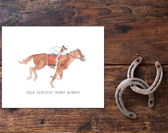 Pode incluir: Uma ilustração em aquarela de um cavalo marrom com um jóquei em uniforme branco e azul. O cavalo está correndo e o jóquei está inclinado para frente. O texto "2018 Kentucky Derby Winner" está abaixo da imagem.