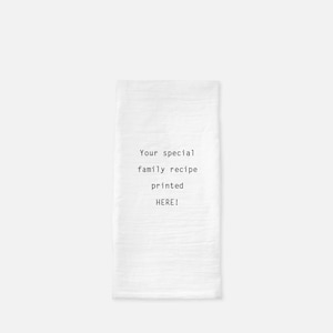 May include: White kitchen towel with the text "Your special family recipe printed HERE!" in black.