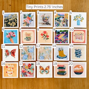 May include: Twenty colourful 2.75 inch square prints featuring various illustrations, including flowers, butterflies, a house, a wheelbarrow, a pair of boots, a stack of books, and a mountain range.