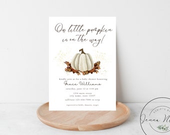 Op de afbeelding: Een witte pompoen met een bruine steel en bladeren, omringd door gouden glitter en herfstbladeren. De tekst "On little pumpkin is on the way!" staat bovenaan de uitnodiging. De uitnodiging bevat ook de tekst "kindly join us for a baby shower honoring Grace Williams Saturday, June 12 at 3:00 pm 1234 Main Street City Name, State 12457 call/text 123-456-7890 to RSVP Registered at Kohl's, Amazon, Target"