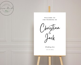 Op de afbeelding: Witte bruiloft welkom bord met zwarte kalligrafie tekst die "Welkom op de bruiloft van Christina & Jack" en "Wedding Site 10.10.2024" luidt.