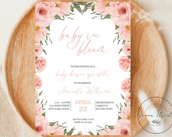 Op de afbeelding: Een roze baby shower uitnodiging met bloemenmotief en de tekst "baby in bloom" en "baby shower sprinkle" in een handschrift. De uitnodiging bevat de datum, tijd en locatie van het evenement, evenals de naam van de persoon die wordt gevierd, Amanda Williams. De uitnodiging bevat ook de tekst "Registered at Target & Buy Buy Baby".
