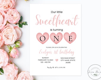 Op de afbeelding: Een witte uitnodigingskaart met roze tekst en hartaccenten. De tekst luidt "Our little Sweetheart is turning ONE" en nodigt gasten uit voor Evelyn's 1e verjaardag op 14 februari 2024. Bloemenelementen omlijsten de kaart.