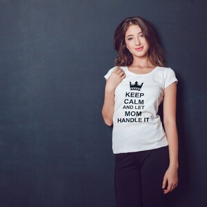 Könnte beinhalten: Weißes T-Shirt mit einer schwarzen Krone und dem Text "Keep Calm and Let Mom Handle It".