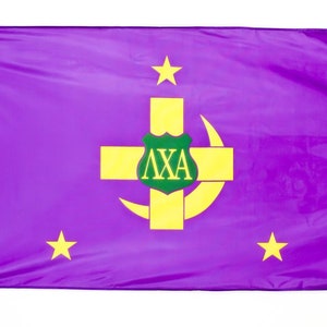Può includere: Una bandiera viola con simboli gialli. La bandiera presenta una croce gialla, una luna crescente e tre stelle. Uno stemma verde con lettere greche è centrato sulla croce. La bandiera è rettangolare.