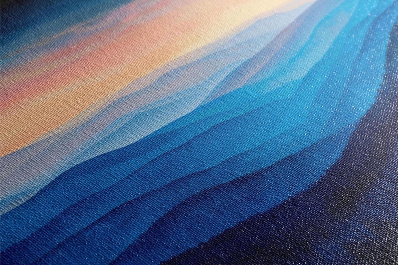 The image is a close-up of a textured fabric with a gradient of blue and orange colors, creating a visually striking pattern.