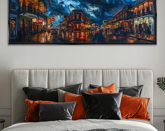 May include: A framed panoramic print of a city street at night, reflecting lights on a wet surface. Buildings with balconies and illuminated signs line the street under a dramatic, cloudy sky. The artwork is displayed above a bed with pillows.