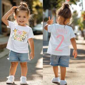 May include: White t-shirt with a pink "Two Wild" graphic on the front and a pink "Sadies 2" graphic on the back. A young child is wearing the shirt and denim shorts.