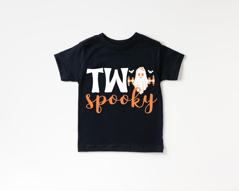 Pu&ograve; includere: T-shirt nera per bambini piccoli con le parole "TWO spooky" in lettere bianche e arancioni. Una grafica di fantasma &egrave; tra le parole "TWO" e "spooky". Due piccoli pipistrelli sono sopra il fantasma.