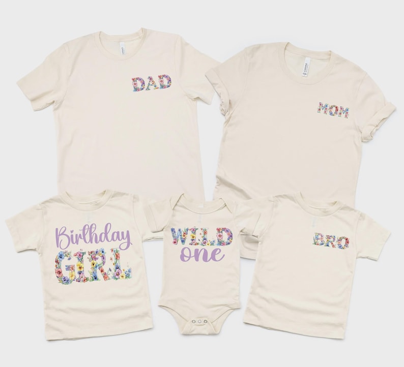 以下が含まれることがあります： クリーム色の衣類5点セット。大人用Tシャツ2枚（花柄のDADとMOMの文字入り）、子供用Tシャツ1枚（紫と花柄のBirthday GIRLの文字入り）、ベビー用ボディスーツ1枚（紫と花柄のWILD oneの文字入り）、子供用Tシャツ1枚（花柄のBROの文字入り）が含まれています。