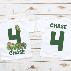May include: White t-shirt with a green number 4 and the name "CHASE" printed on the front. The back of the shirt has a green number 4 and the name "CHASE" printed on the back. The shirt features a green iguana, a snake, and a frog.
