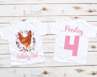 Op de afbeelding: Wit T-shirt met een bruine kip omringd door roze bloemen en de tekst "Birthday Chick". De achterkant van het shirt heeft de naam "Presley" en het nummer "4" in roze.