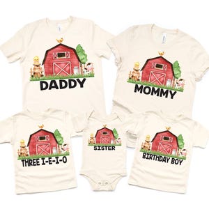 May include: A set of four cream-colored t-shirts featuring a red barn with a yellow chick on top, green grass, and farm animals. The shirts have the words "Daddy", "Mommy", "Sister", and "Birthday Boy" printed on them.