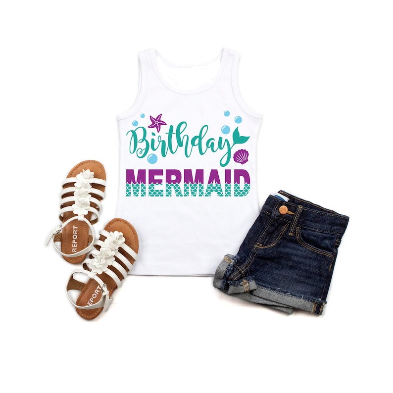 May include: White tank top with the text "Birthday Mermaid" in purple and teal lettering. The text is decorated with a purple starfish, a teal mermaid tail, and a pink seashell.