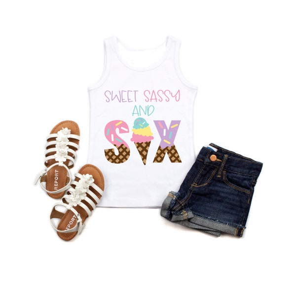 May include: A white vest top with the text "Sweet Sassy and Six" in pastel colours, alongside denim shorts and white sandals with flower accents. The word "Six" is designed as ice cream cones.