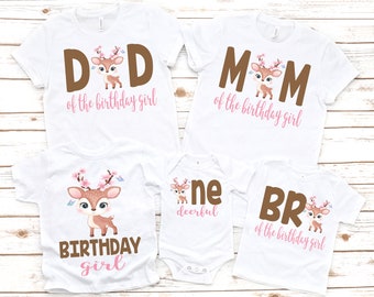 May include: A set of four white t-shirts with brown and pink text and a cartoon deer design. The shirts say "Dad of the birthday girl", "Mom of the birthday girl", "Birthday girl", and "Bro of the birthday girl".