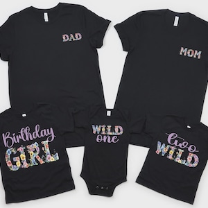 以下が含まれることがあります： 花柄のDADとMOMの文字が入った大人用Tシャツ2枚、花柄のBirthday GIRLの文字が入った子供用Tシャツ、花柄のWILD oneの文字が入ったベビー用ボディスーツ、花柄のtwo WILDの文字が入った子供用Tシャツを含む、5着の黒い衣類のセット。