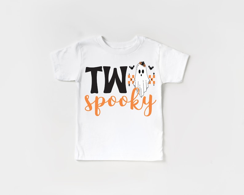 Pu&ograve; includere: T-shirt bianca con le parole "TWo spooky" in lettere nere e arancioni. Un fantasma dei cartoni animati con pipistrelli e candele &egrave; stampato sulla maglietta. La maglietta &egrave; a girocollo e maniche corte.
