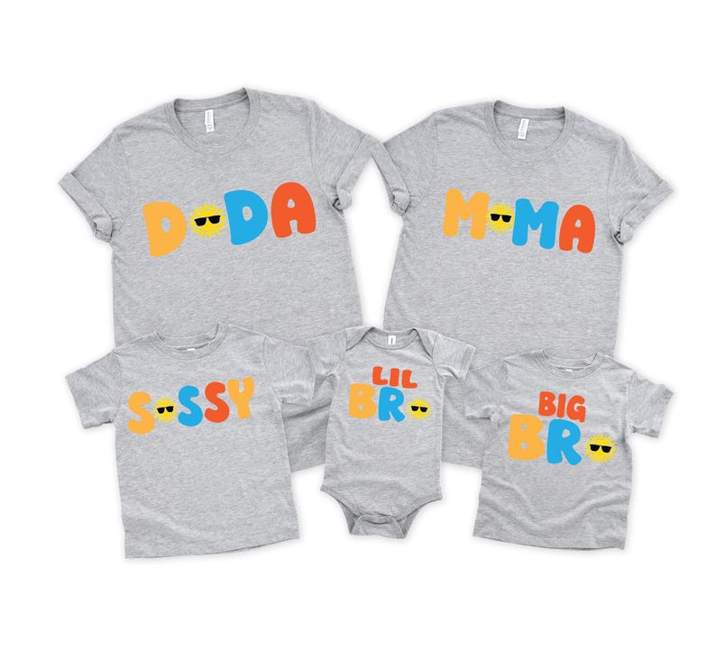May include: Five heather grey garments including two adult t-shirts, two children's t-shirts, and one infant bodysuit. The shirts feature colourful text: DADA, MAMA, SISSY, LIL BRO, and BIG BRO, with yellow sun icons wearing black sunglasses.