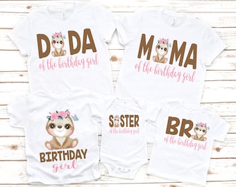 May include: Set of five white t-shirts with brown text and a sloth graphic. The shirts say "Doda of the birthday girl", "Mama of the birthday girl", "Birthday girl", "Sister of the birthday girl", and "Bro of the birthday girl".